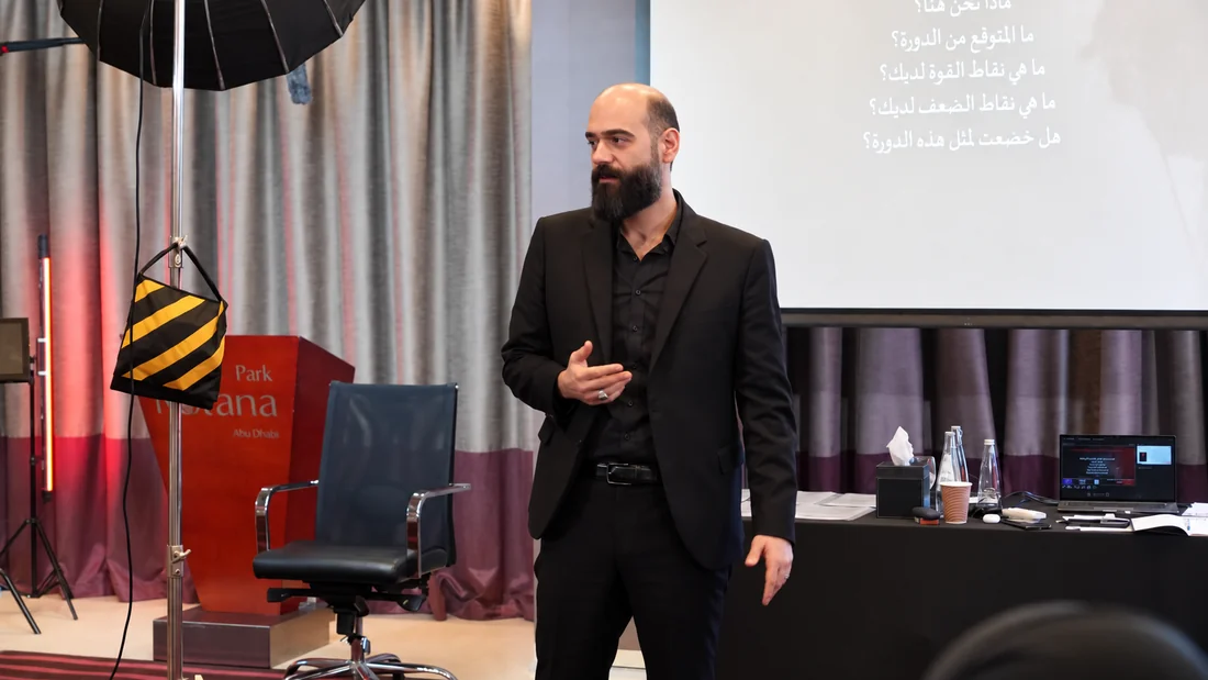سومر يشرح للمشاركين داخل قاعة مجهّزة للتدريب الإعلامي